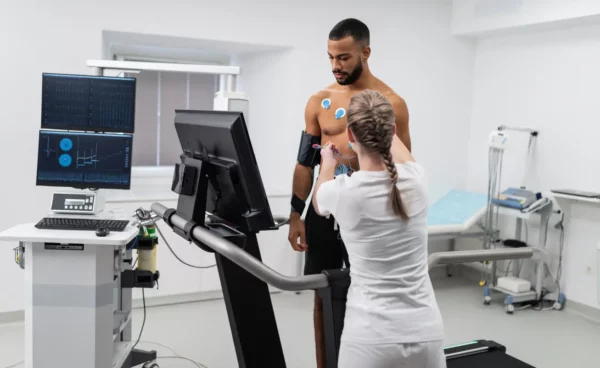 female EKG technician hooking up black male to machine