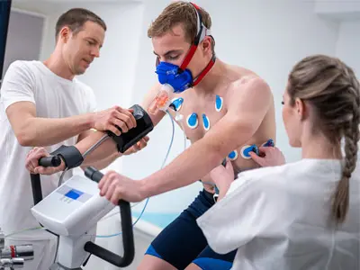 Male and female doctor preparing young male athlete before a stress test in clinic.