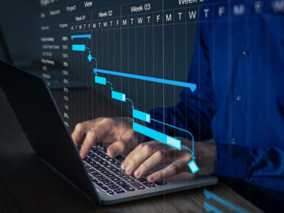 Project manager working on Gantt chart to update the schedule, tasks and milestones progress for the team. Management diagram on computer screen with person coordinating teamwork.